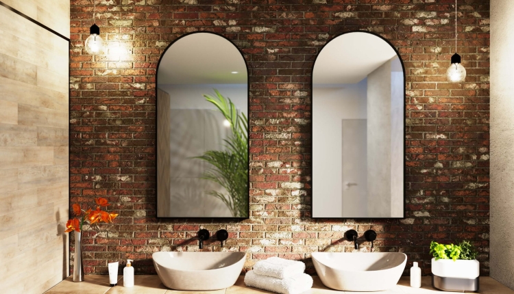 Lustro półowalne MALAGA w czarnej ramie na tle ceglanej ściany